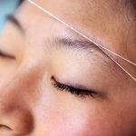 eyebrow waxing with threading on a young woman